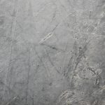 Close-up of a textured grey stone surface suitable for backgrounds or wallpapers.